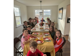 A group of children surrounding a dinner table during the holidays